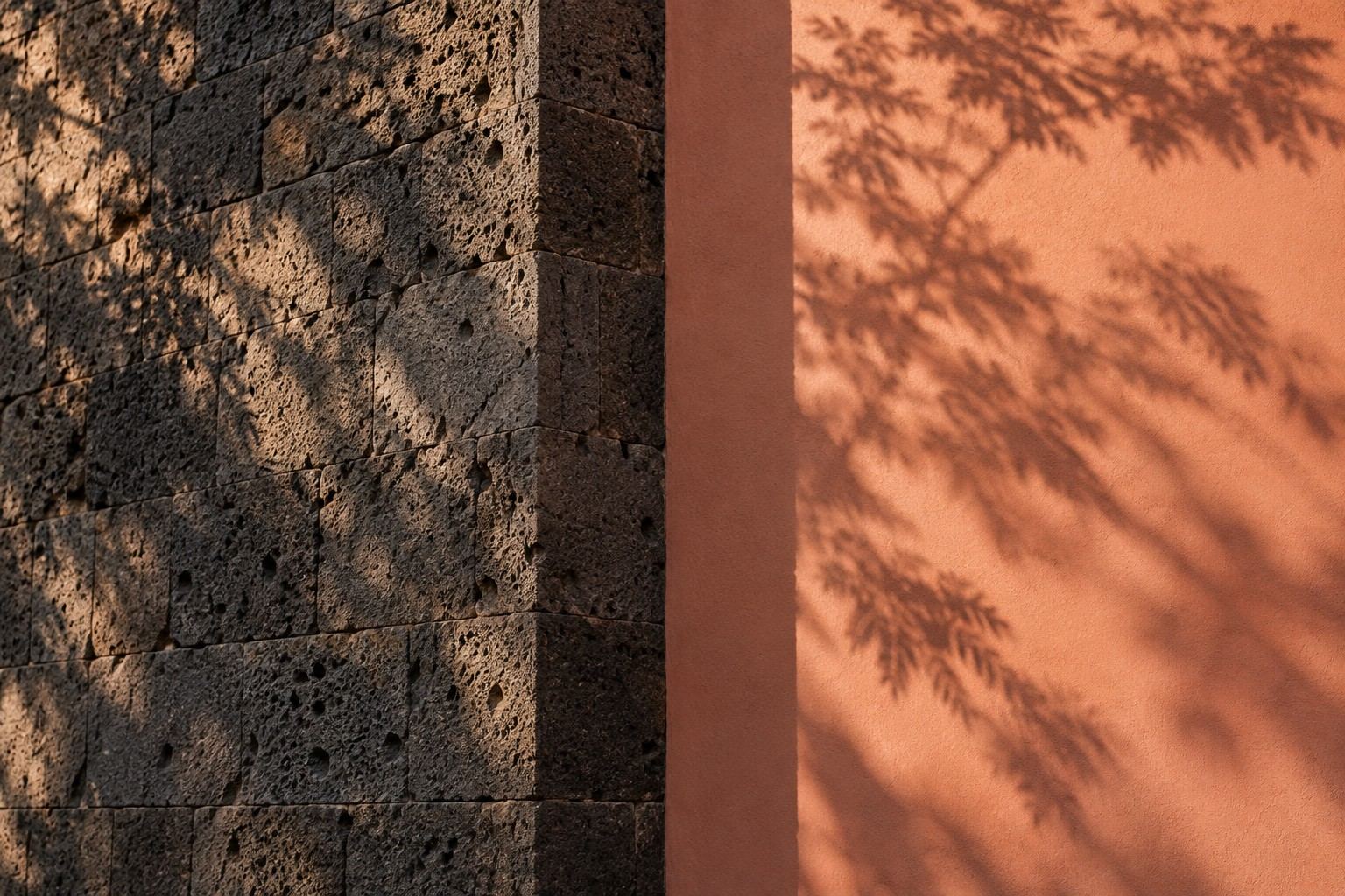 Volcanic-stone wall beside a terracotta wall with jacaranda shadows